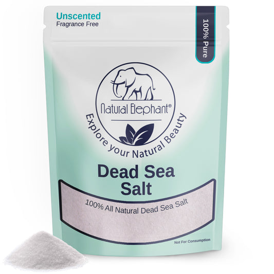A package of Natural Elephant Fine Dead Sea Salt, labeled Unscented and 100% Pure, with a small pile of exfoliating white salt beside it. The light green and white packaging features an elephant logo and highlights its therapeutic properties.