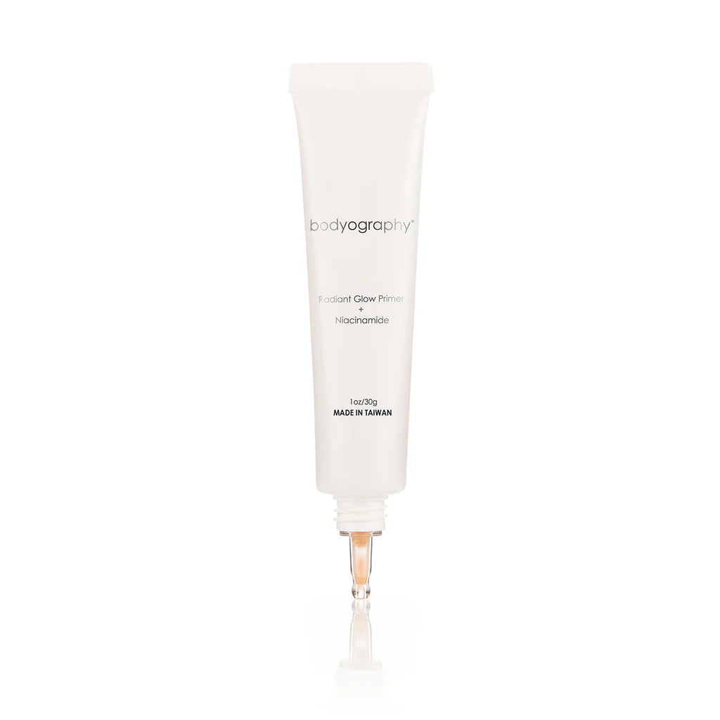 A white tube of Bodyography Radiant Glow Primer + Niacinamide stands upright on a white background, showcasing a clear applicator tip and minimalistic labeling.