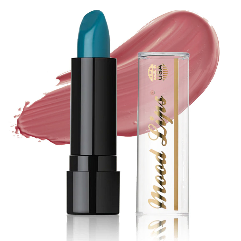 A Mood Lips Color Changing Lipstick in a black tube sits by its clear cap with gold Mod Lips text. Behind them, a mauve smear pops on white, showcasing these antioxidant vitamin-enriched, long-lasting lipsticks.