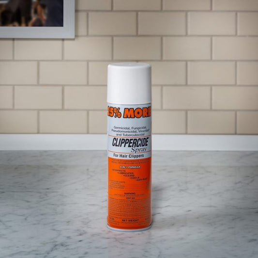 Barbicide Clippercide spray for hair clippers in a spray can on a marble countertop