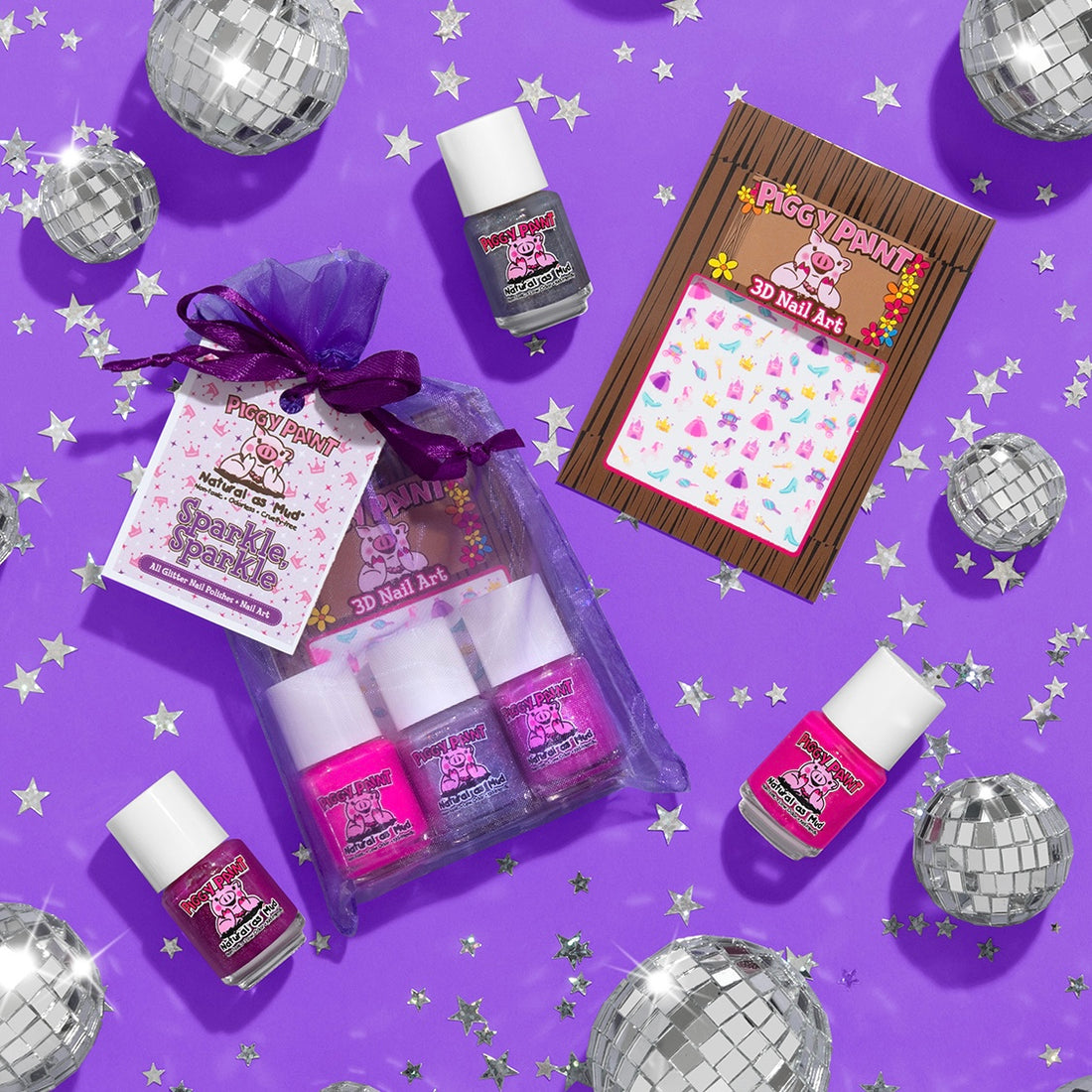 Piggy Paint Sparkle, Sparkle set features non-toxic, cruelty-free vegan nail polishes in gray, pink, and purple. Includes a purple mesh bag with 3D kid-friendly nail art stickers, mini disco balls, and silver star confetti on a purple background.
