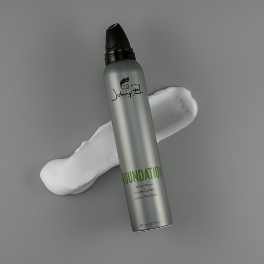 Johnny B Foundation Styling Mousse in a sleek silver can with a generous amount of mousse beside it