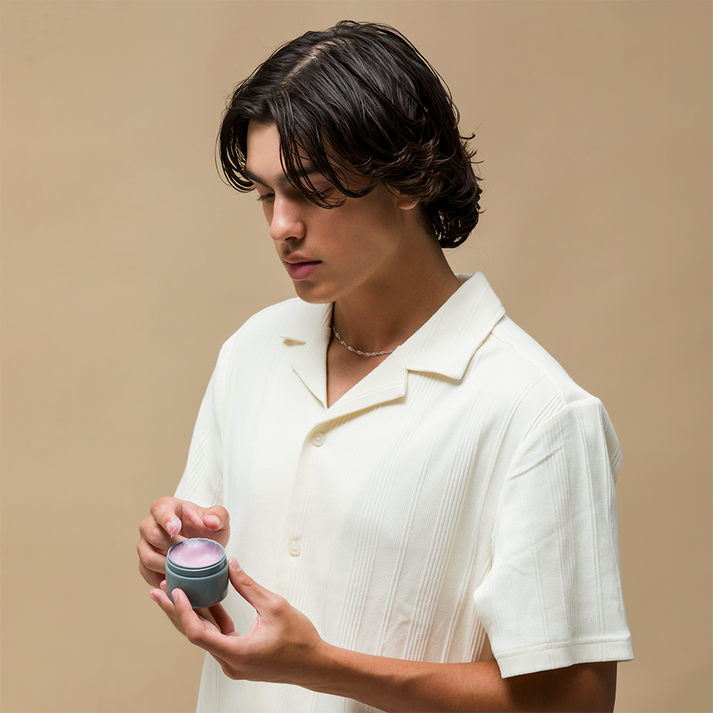 Johnny B Lava Clay Pomade in a male model's hand for styling and grooming hair