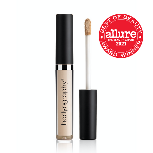 A tube of Bodyography Skin Slip Full Coverage Concealer #L1 - Cool Light with a black cap is shown open beside its applicator wand and a red “Allure Best of Beauty Award Winner 2021” badge—ideal for brightening under-eyes with full coverage.