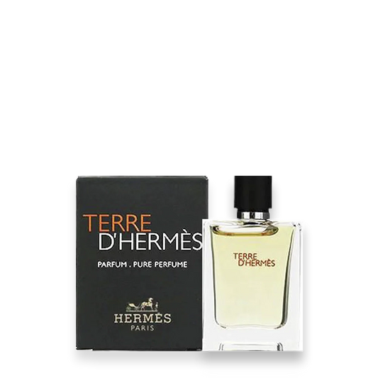 A bottle of Hermes Terre d’Hermes Parfum with a black cap is shown beside its black box packaging, displaying the brand name and logo in orange and white—an elegant Woody Chypre scent with oak moss notes.