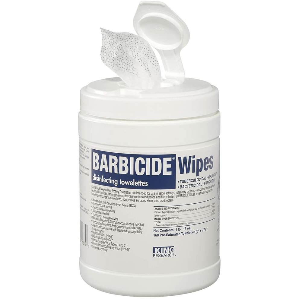 A container of Barbicide Wipes, 160 Count, with the lid open and one wipe partially pulled out. The white container displays blue and black text listing uses and details for compliance with sanitation guidelines.