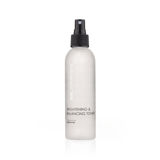 A white spray bottle with a black nozzle, labeled Bodyography Skin Care Brightening & Balancing Toner 6 oz, stands upright against a plain white background.
