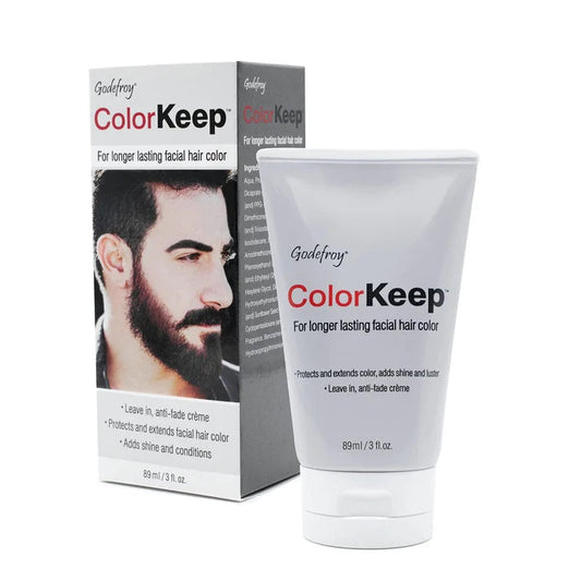 A tube and box of Godefroy Color Keep Facial Hair and Beard Color 3 fl oz, designed for facial hair protection and color retention. The box shows a bearded man with product details; the tube displays the name and usage info.
