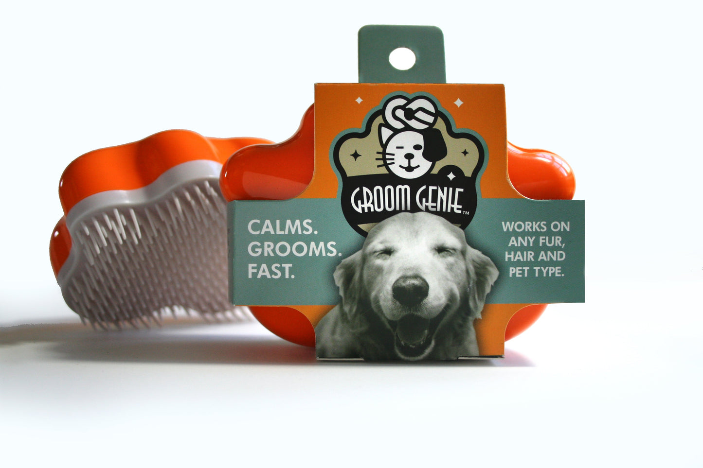 The Groom Genie Original Pet Detangling Brush, shown in orange and white with unique bristles, is a must-have for grooming any pet. Its packaging features a happy dog and the tagline Calms. Grooms. Fast. Suitable for all fur and hair types.
