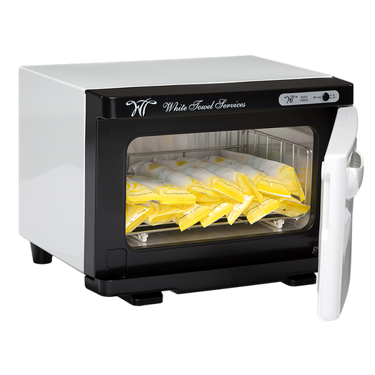 The White Towel Services Deluxe Towel Warmer - WT-7B, shown with its door open, displays neatly arranged individually wrapped yellow and white Refreshment Towels on the rack. White Towel Services is printed on the top front panel. Includes a Lifetime Warranty.