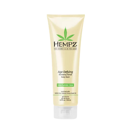 An 8.5 fl. oz. beige tube of Hempz Herbal Body Wash Age Defying Scent, featuring a green leaf logo and enriched with 100% pure vegan hemp seed oil, stands upright against a white background.
