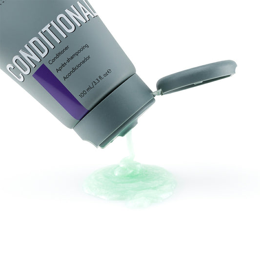 Johnny B Conditional Conditioner in a gray squeeze tube with green product flowing out