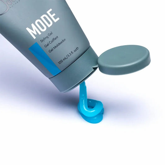 Johnny B. Mode styling gel in a gray tube with a blue gel pouring out for hair styling