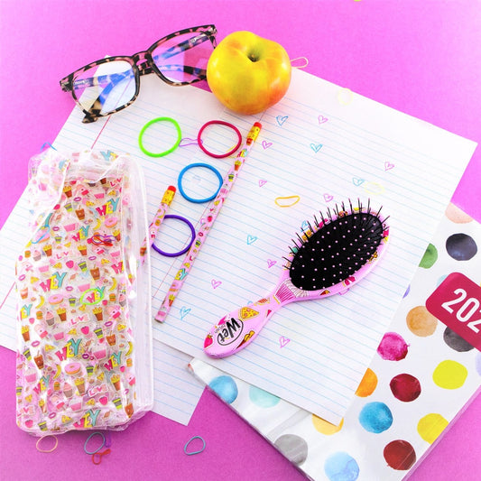Wet Brush kids detangling brush kit with colorful accessories on a vibrant study desk