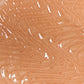 A close-up of a fingerprint pattern on human skin with a shiny, reflective surface, possibly enhanced by Bodyography Radiant Glow Primer + Niacinamide for a luminous finish.