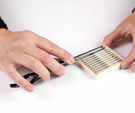 Hands holding a Feather Razor Blade with a protected case for safe storage and easy access