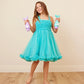 Smiling girl in a turquoise dress holding Glimmer Wish Mermaid Shampoo bottles, perfect for mermaid-themed hair care