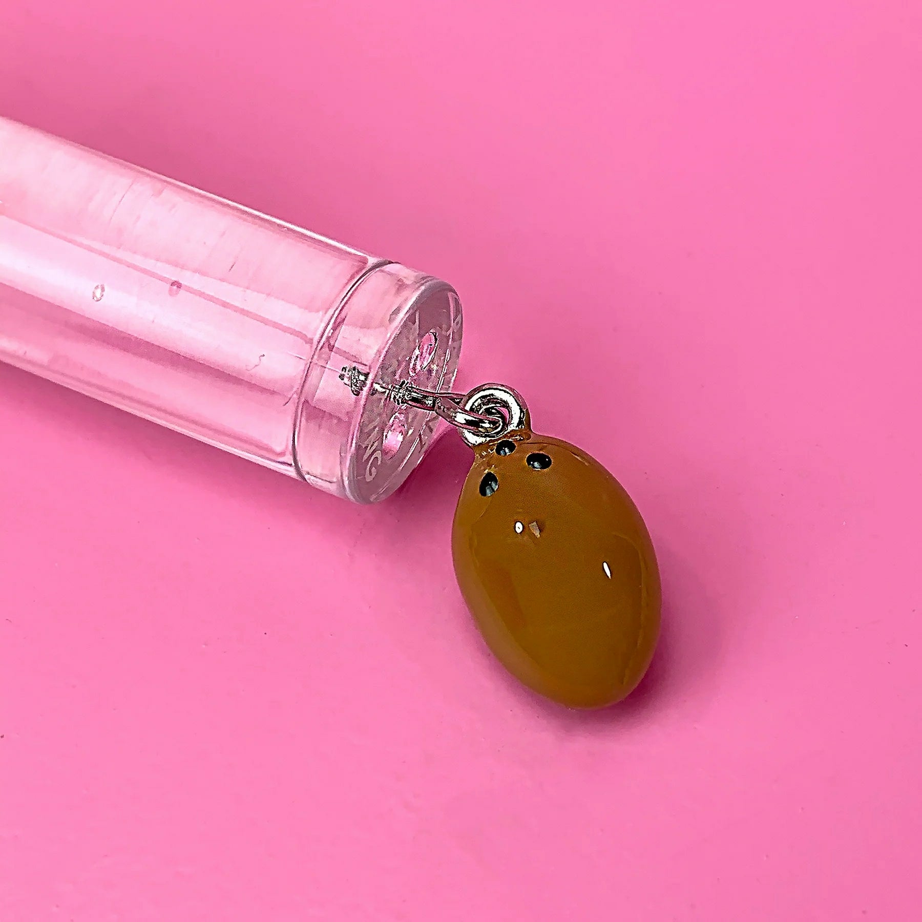 Glossy Pops tropical coconut lip balm tube with a unique coconut charm attached
