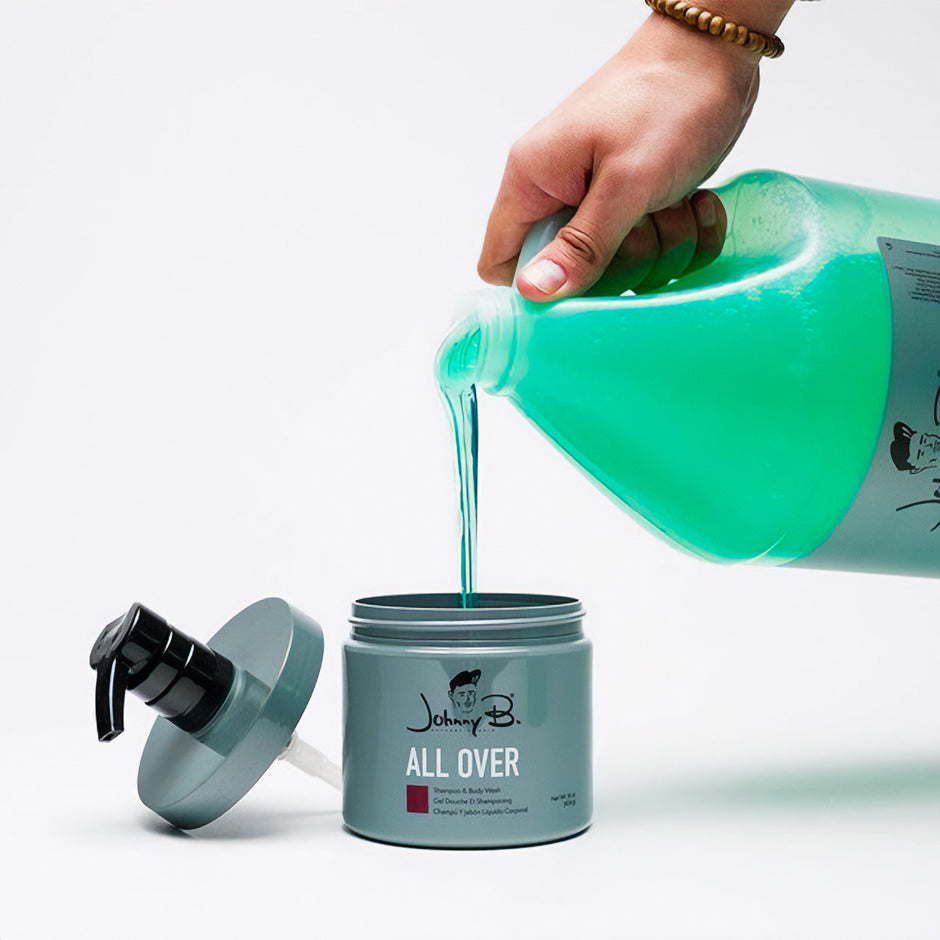 Hand pouring Johnny B. All Over Shampoo and Body Wash into a pump bottle, showcasing vibrant blue liquid