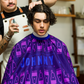 Johnny B. cutting cape in purple with iconic design for professional haircuts and styling