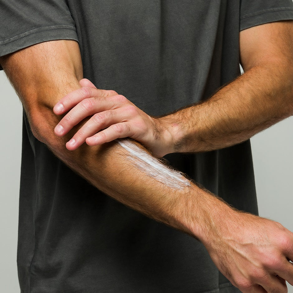 Person applying Johnny B leave-in conditioner to their arm for hydration and nourishment