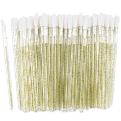 A set of Apothie Disposable Lip Applicator Wands (100 ct) in clear plastic tubes with white foam stoppers, filled with light yellow liquid; one tube is separated from the group, evoking precise makeup application.