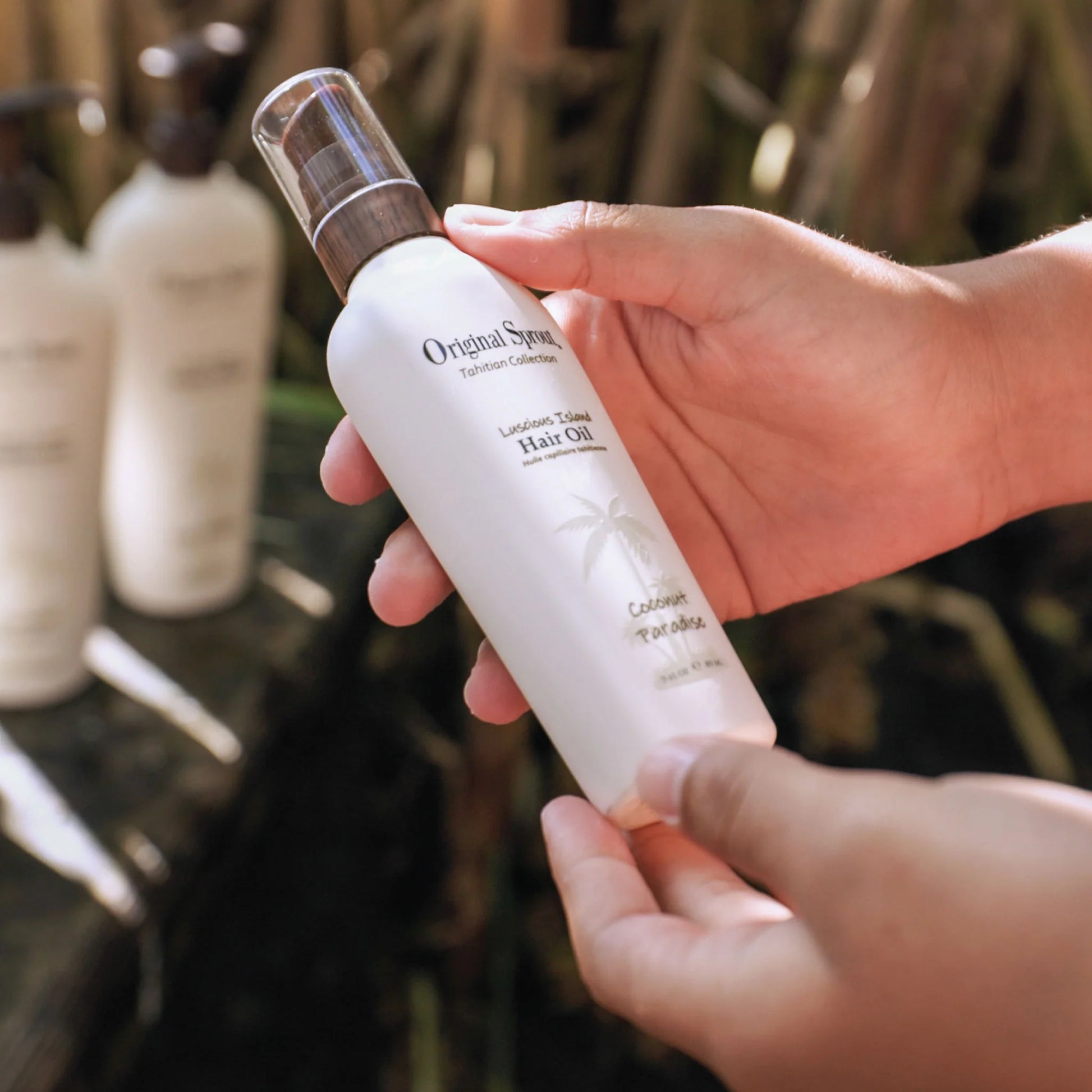 Original Sprout hair oil in a sleek bottle, held in hands against a natural background