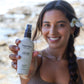Original Sprout protein mist in Tropical Citrus by a smiling woman at the beach