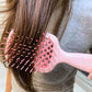 Unbrush detangling hair brush in pink, gently smoothing through long hair strands for effortless detangling