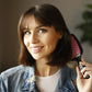 Unbrush detangling hair brush held by a smiling woman with medium-length hair, ideal for smooth styling