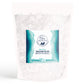 An 8 oz resealable white pouch of Natural Elephant Dead Sea Magnesium Flakes features a blue and teal mountain label highlighting muscle relaxation benefits.