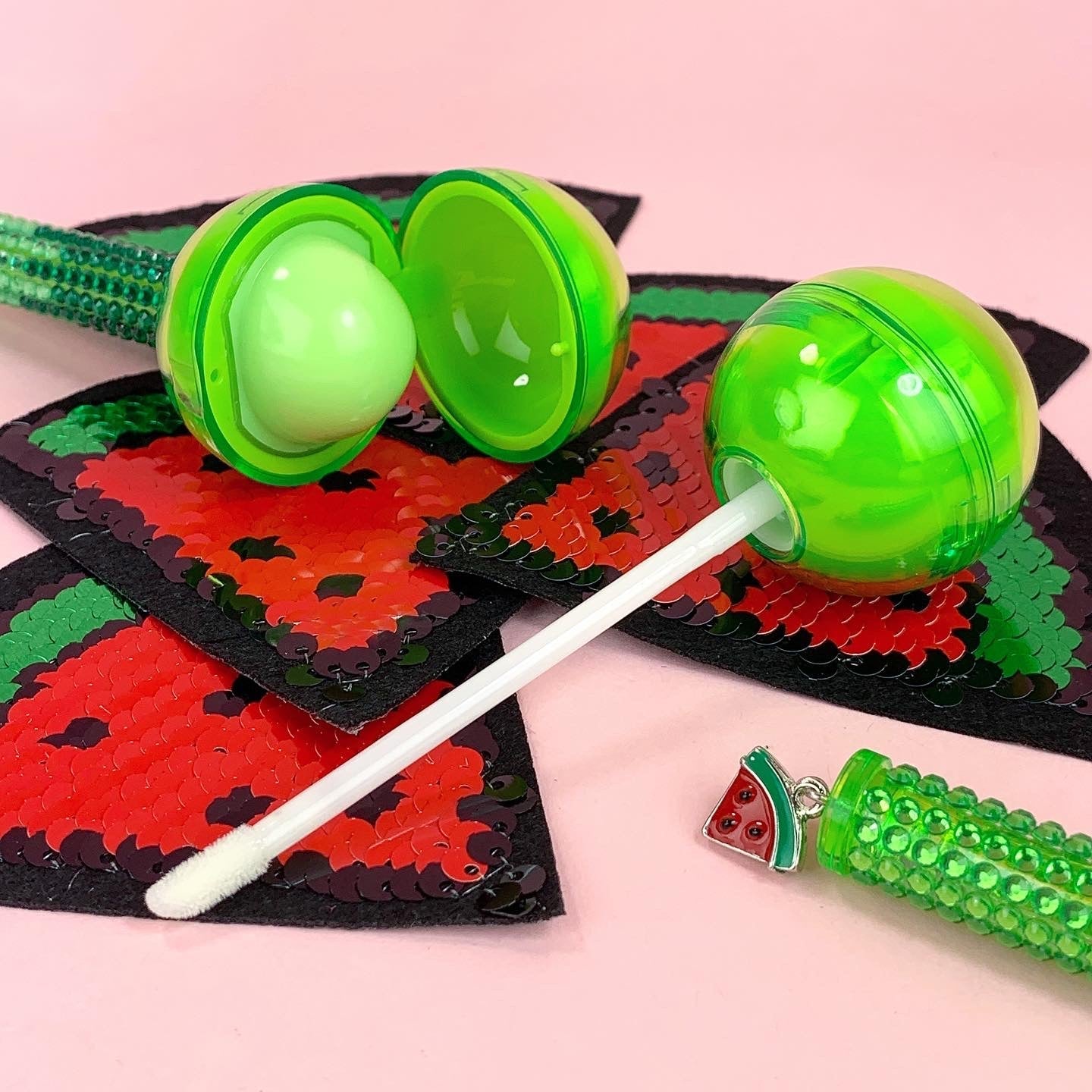 Glossy Pops TGI Fruity lip balm in a fun green watermelon-inspired packaging with a shiny finish