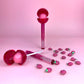 Glossy Pops TGI Fruity lip balm with vibrant pink design and decorative crystals on the tube