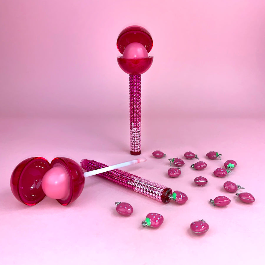Glossy Pops TGI Fruity lip balm with vibrant pink design and decorative crystals on the tube
