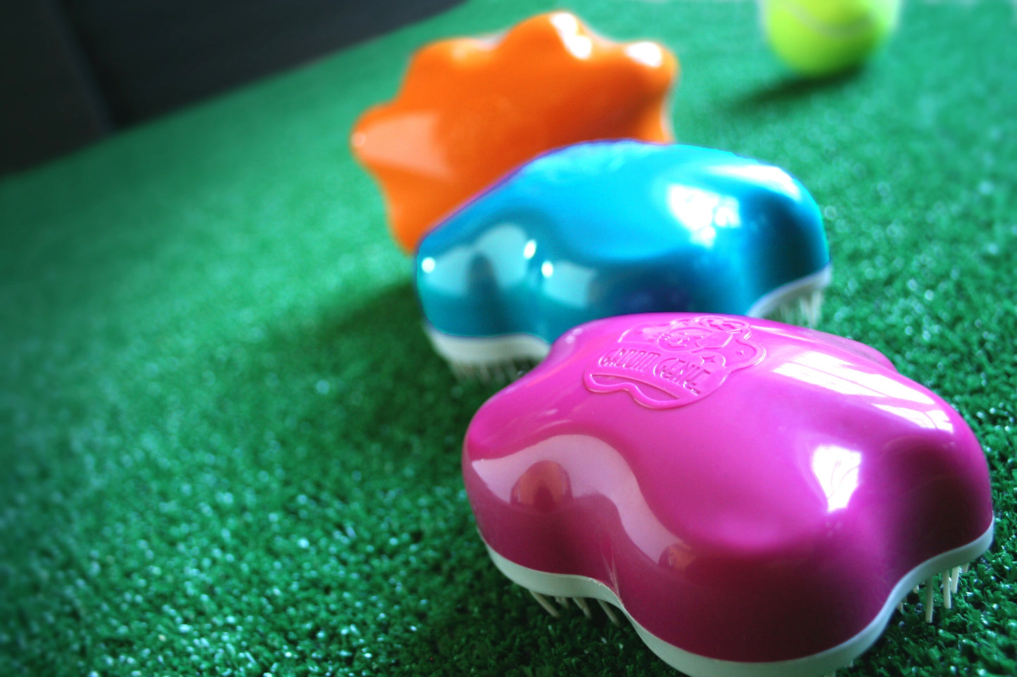 Colorful Groom Genie pet detangling brush in various shapes for easy grooming of pets