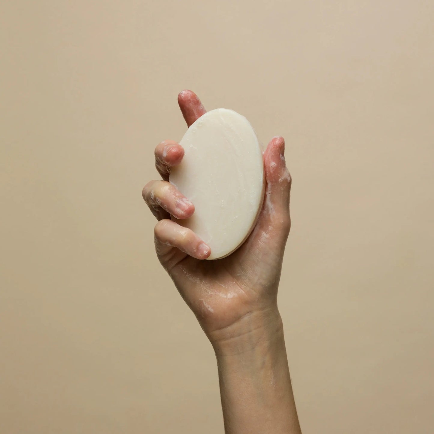 Johnny B Ultra Bar Soap in a hand showing its creamy texture for effective cleansing