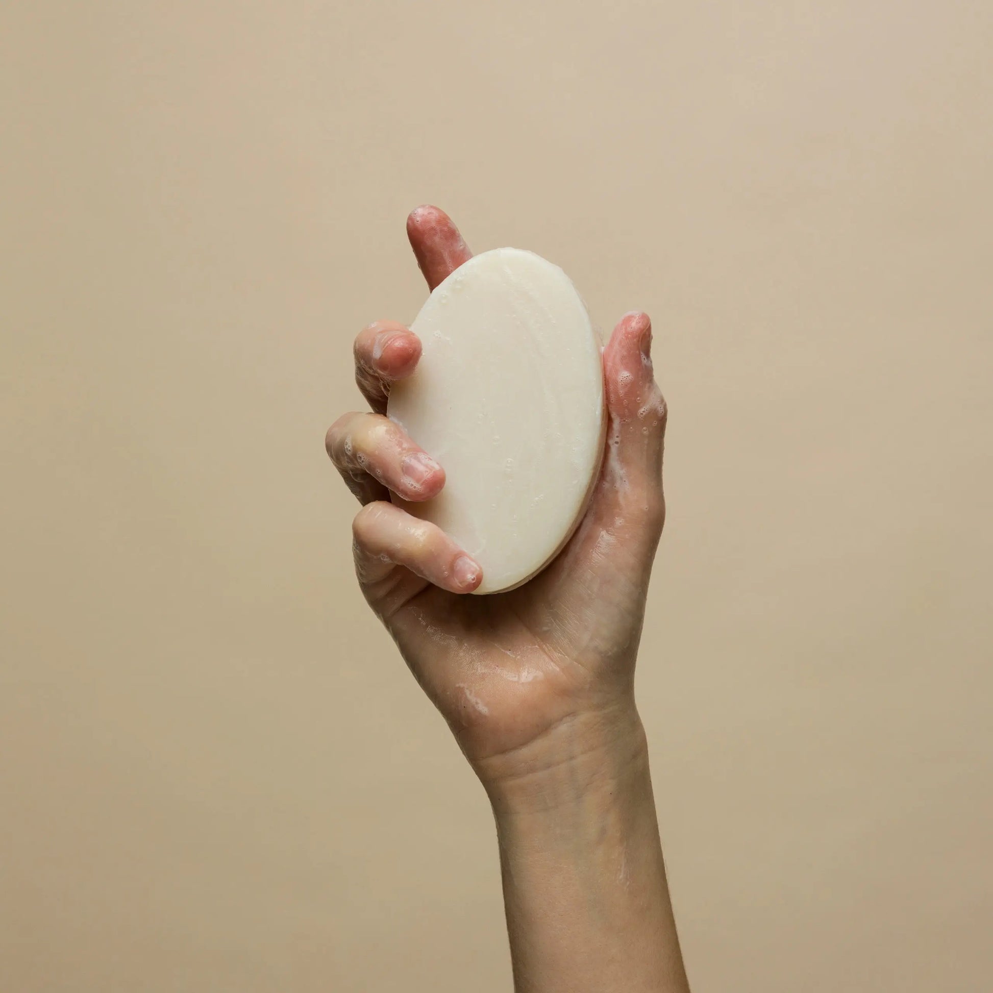 Johnny B Ultra Bar Soap in a hand showing its creamy texture for effective cleansing