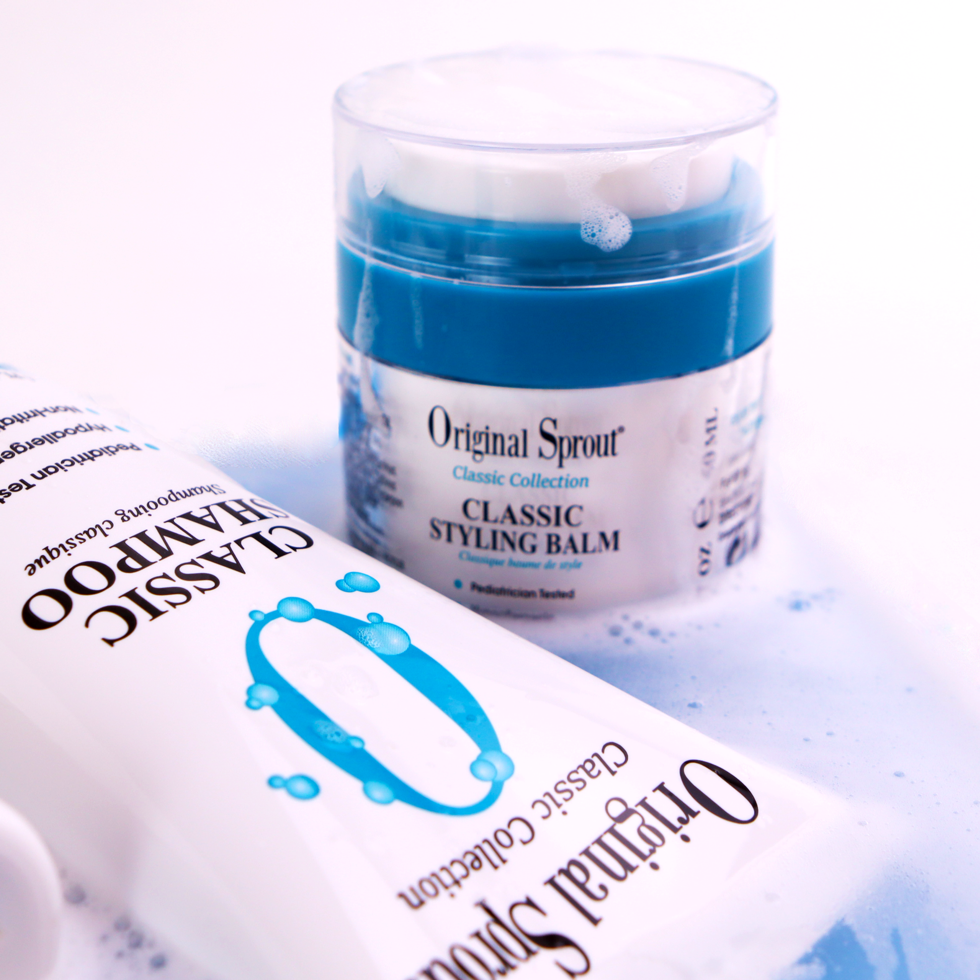 Original Sprout Classic Styling Balm in a clear jar with a blue lid, surrounded by shampoo bottles