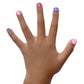 Child's hand displaying colorful designs using Piggy Paint nail art stickers