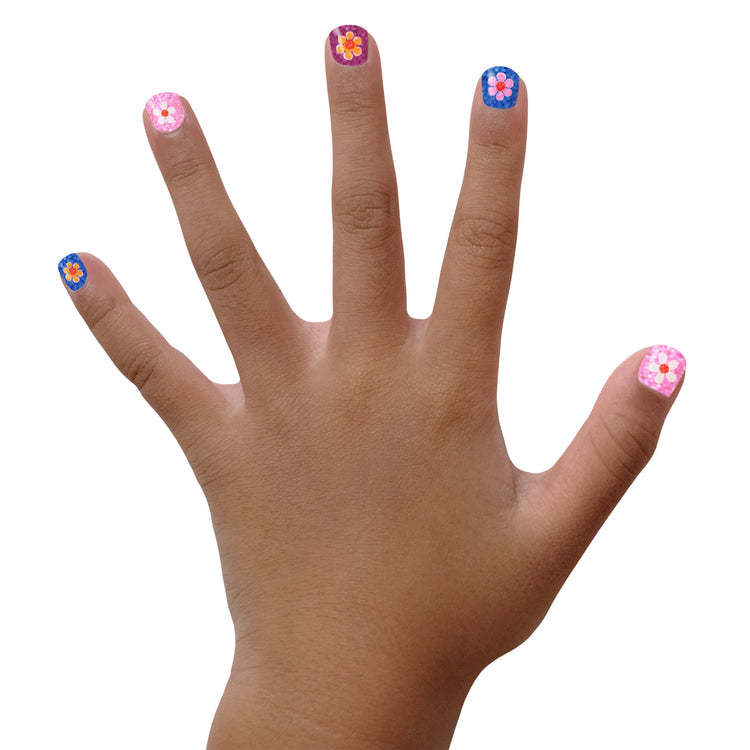 Child's hand displaying colorful designs using Piggy Paint nail art stickers