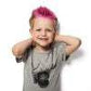 Child with vibrant pink hair using Rock The Locks pink hair color conditioner for colorful hair