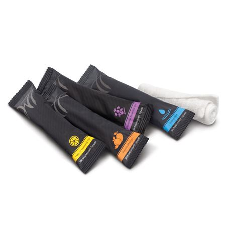 Assorted scented refreshment towels in sleek black wrappers with visible labels for lemon, peach-mango, lavender, and unscented options.