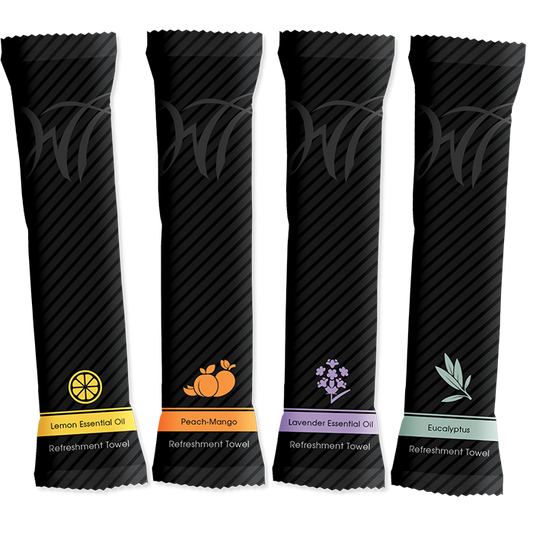 Four black refreshment towel packets, each labeled with a different scent: lemon, peach-mango, lavender, and eucalyptus.